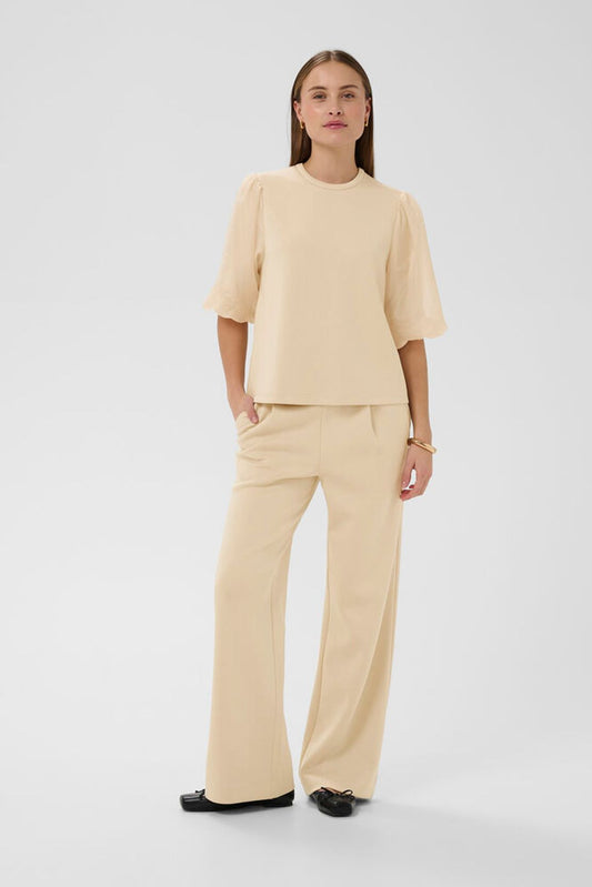 Frontansicht der Soaked Marigold Pants - White Pepper an einem Model mit geradem, fließendem Schnitt