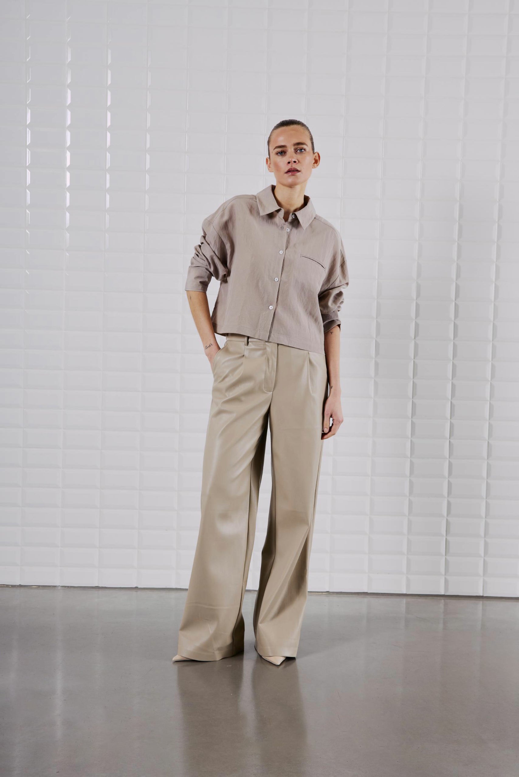 Frontansicht des WithBlack Quinie Cropped Shirt Mineral Gray, kombiniert mit weiter Hose für einen modernen Look.