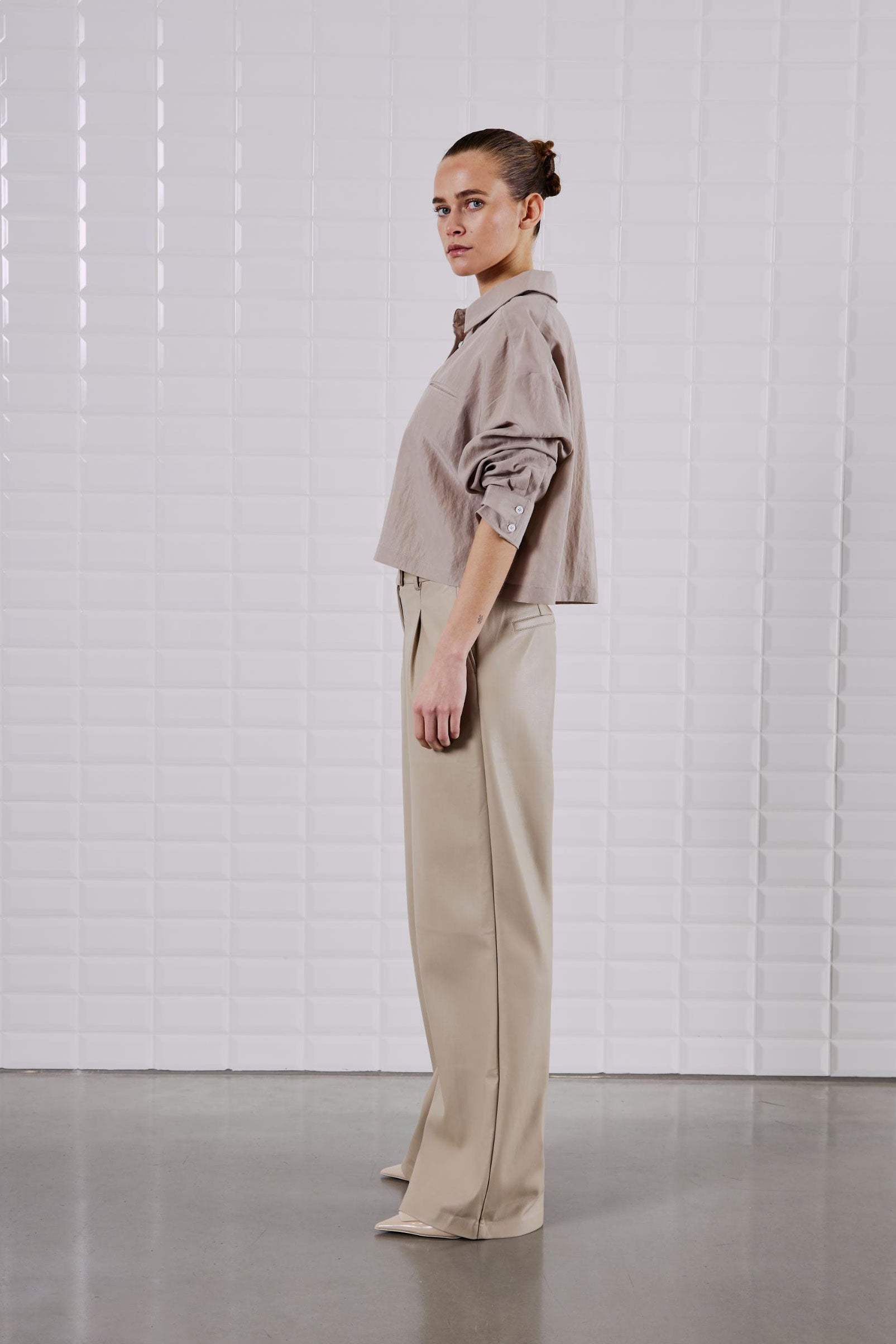 Seitenansicht des WithBlack Quinie Cropped Shirt Mineral Gray, locker geschnitten mit Brusttasche und geknöpften Manschetten.