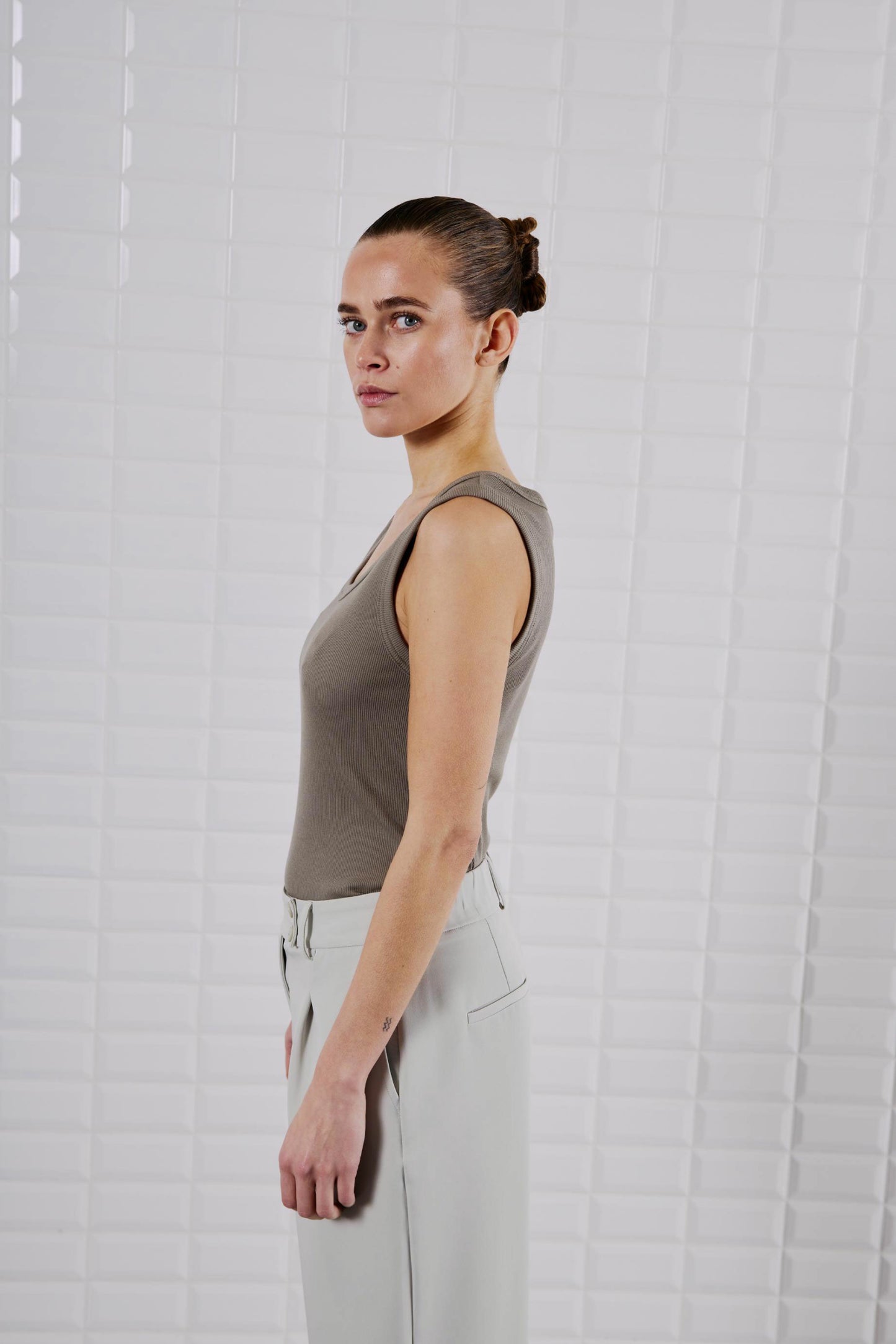 Seitenansicht des WithBlack Lulu Tank Top Light Stone Grey, figurbetont geschnitten mit weichem Rippstoff.