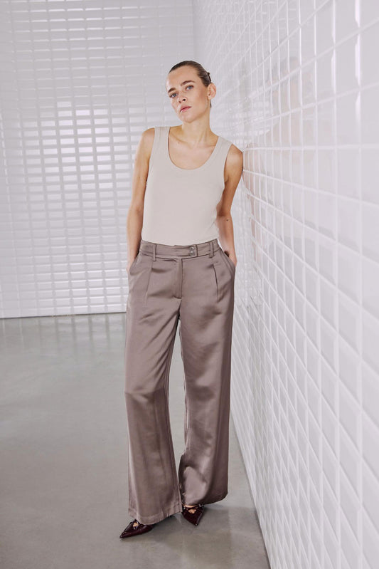 Eleganter Look mit dem WithBlack Lulu Tank Top in Silver Lining, kombiniert mit einer hochgeschnittenen, fließenden Hose.