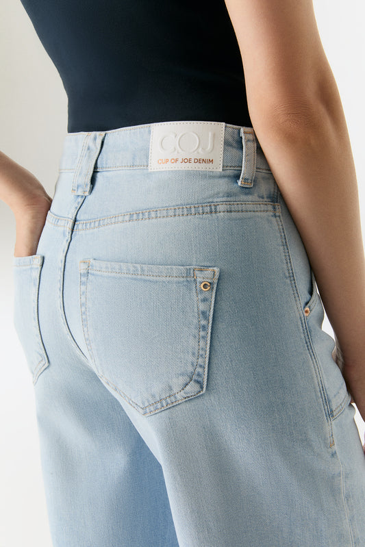 Nahaufnahme der COJ Lulu Wide Leg Aqua Blue Jeans mit Fokus auf das COJ-Label und die Gesäßtasche.
