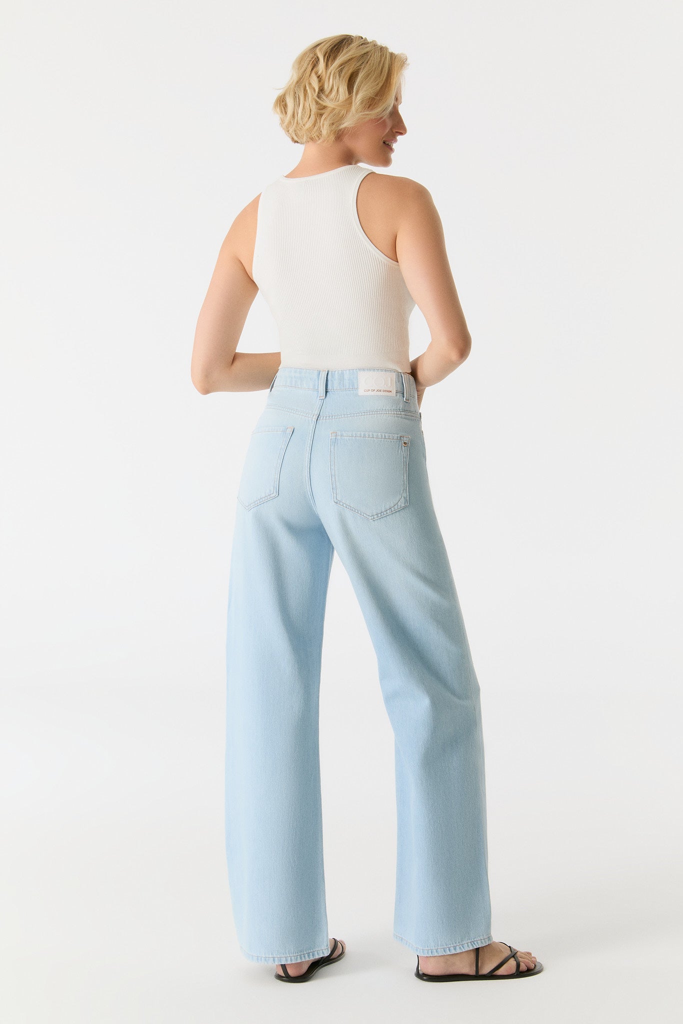 Rückansicht der COJ Maria Wide Leg Light Blue Destroyed Jeans mit einem weißen Top, zeigt die Passform und das Design der Jeans.