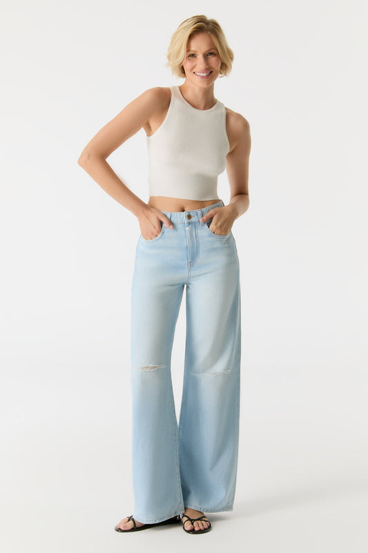 Model trägt die COJ Maria Wide Leg Light Blue Destroyed Jeans in voller Länge mit High-Waist-Schnitt und modischen Rissen.