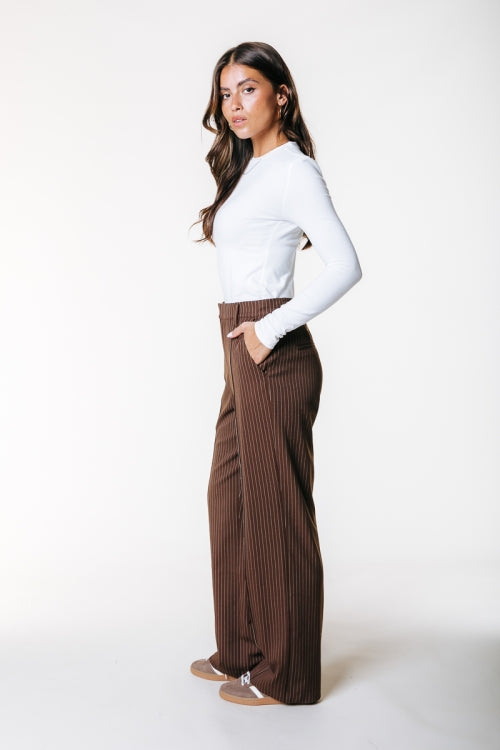 Seitenansicht der Colourful Rebel Rus Pinstripe Straight Pants - Brown, kombiniert mit weißem Shirt.