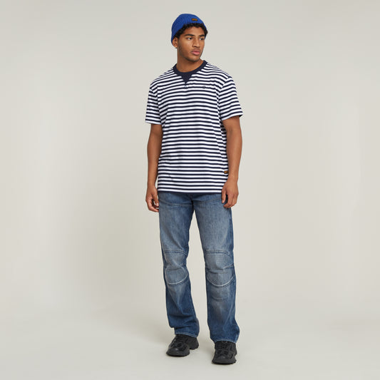 Model trägt die G-Star Elwood 5620 3D - Regular - Worn In Blue Creek Jeans in Frontansicht kombiniert mit gestreiftem T-Shirt