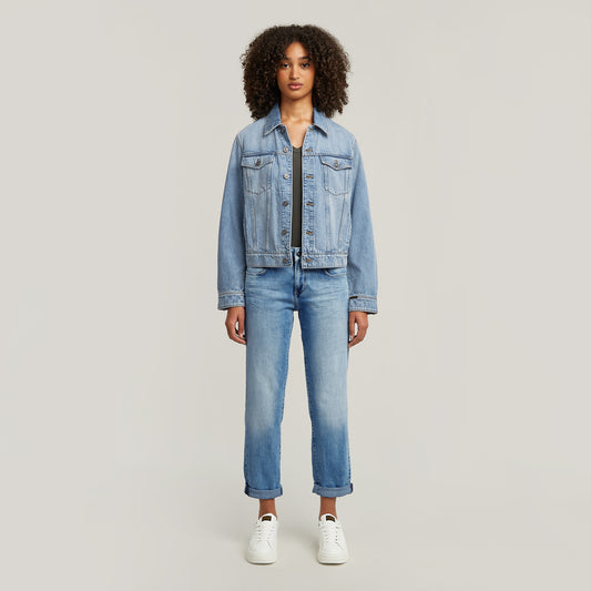 Ganzkörperansicht einer Frau, die die G-Star Kate Boyfriend Jeans in Light Indigo Aged mit hochgekrempeltem Saum und einer Jeansjacke trägt.