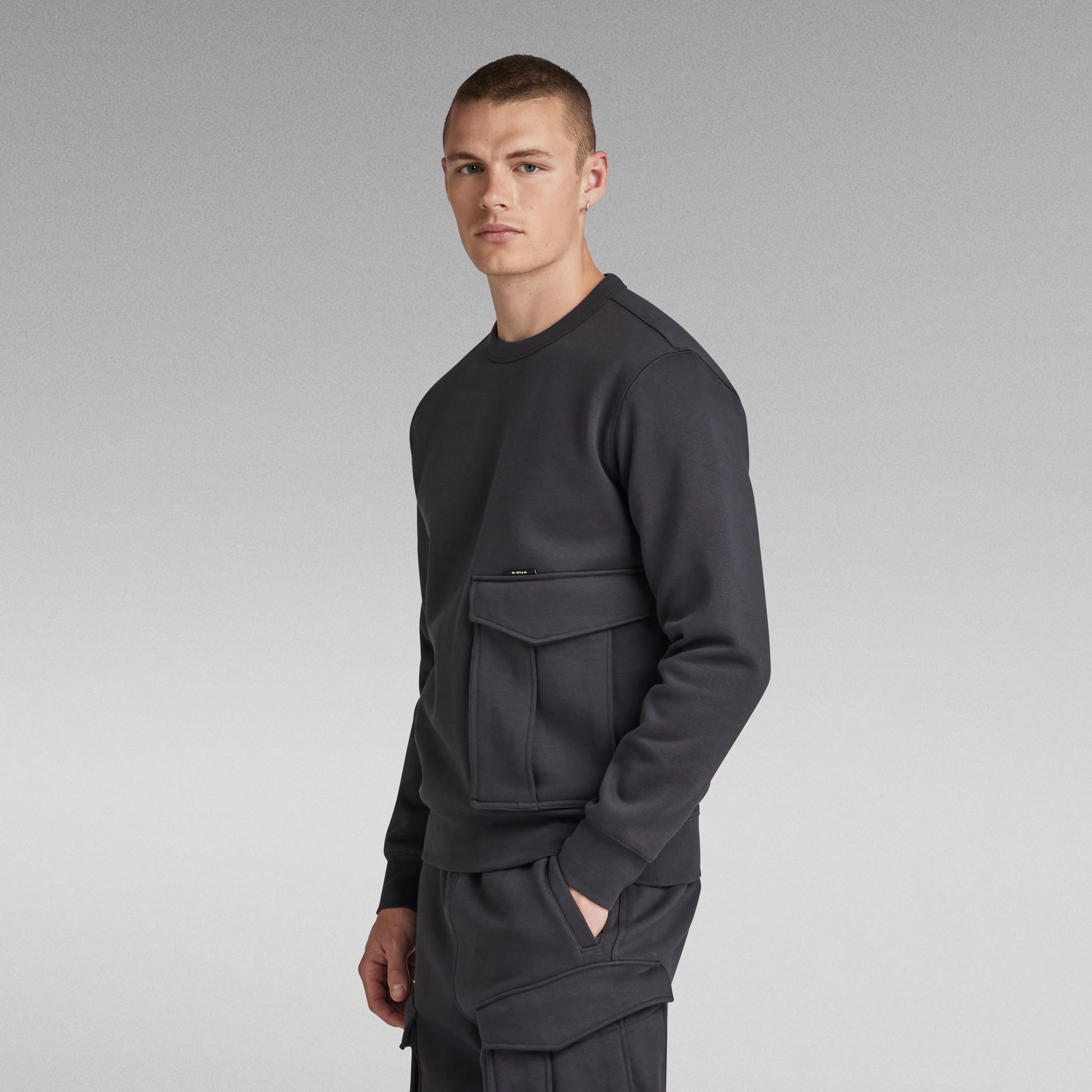 G-Star Pullover Cargo R Sw in Anthrazit, seitliche Ansicht mit Fokus auf die Vordertasche.