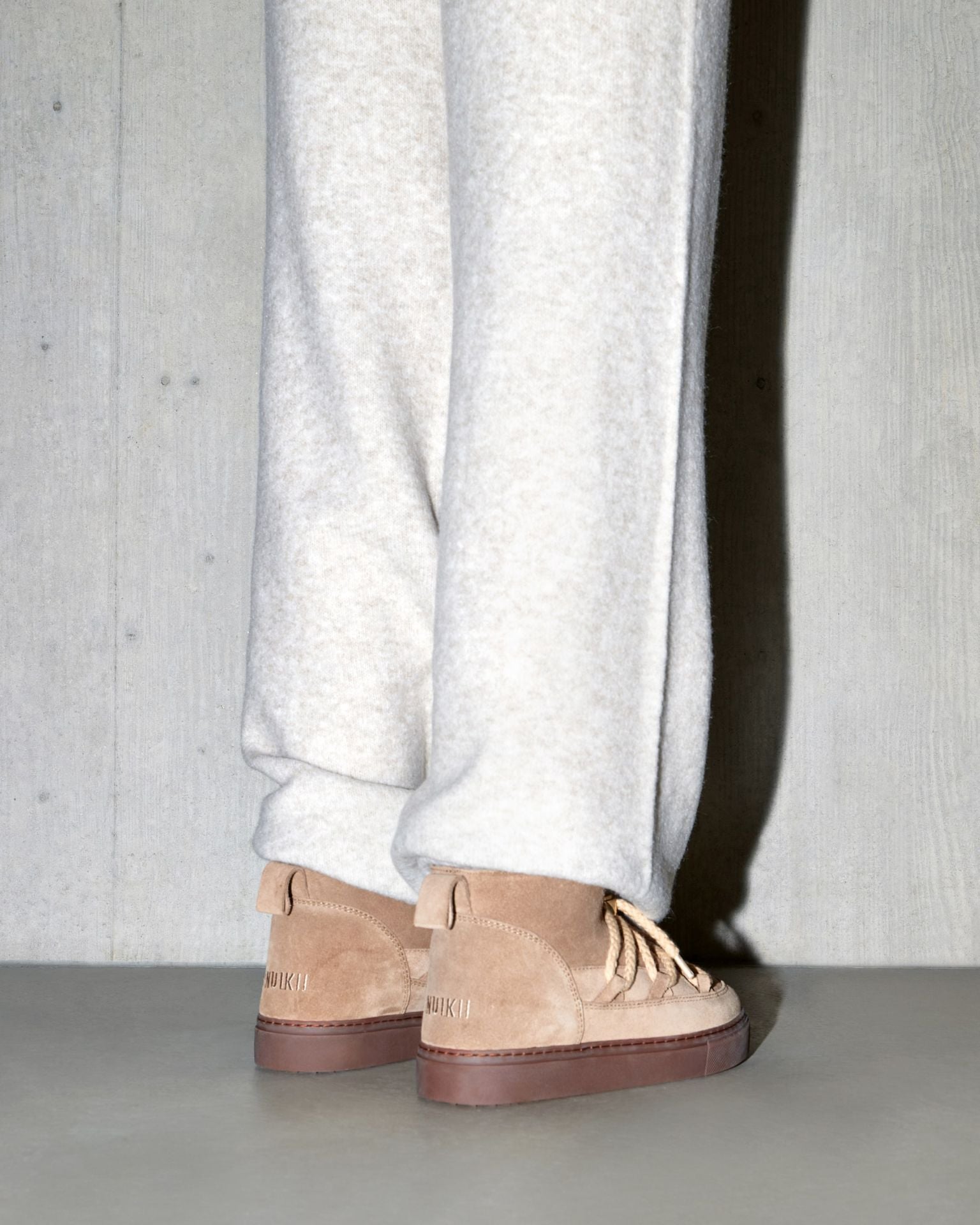 Inuikii Classic Low Beige – Rückansicht des Sneakers mit sichtbarem Logo und warmem Veloursleder
