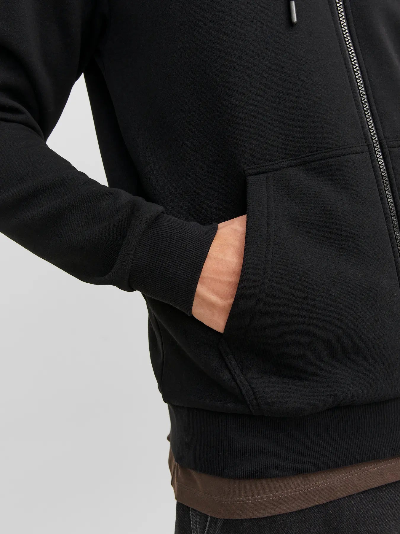 Nahaufnahme der Kängurutasche des Jack&Jones Bradley Sweat Zip Hood Black mit geripptem Saum und Eingrifftasche.