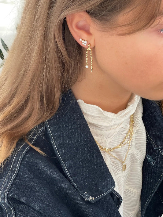 Jeberg Jewellery Harmony Pearl Double Earring getragen, kombiniert mit weiteren Ohrringen und goldenen Ketten für einen eleganten Layering-Look.