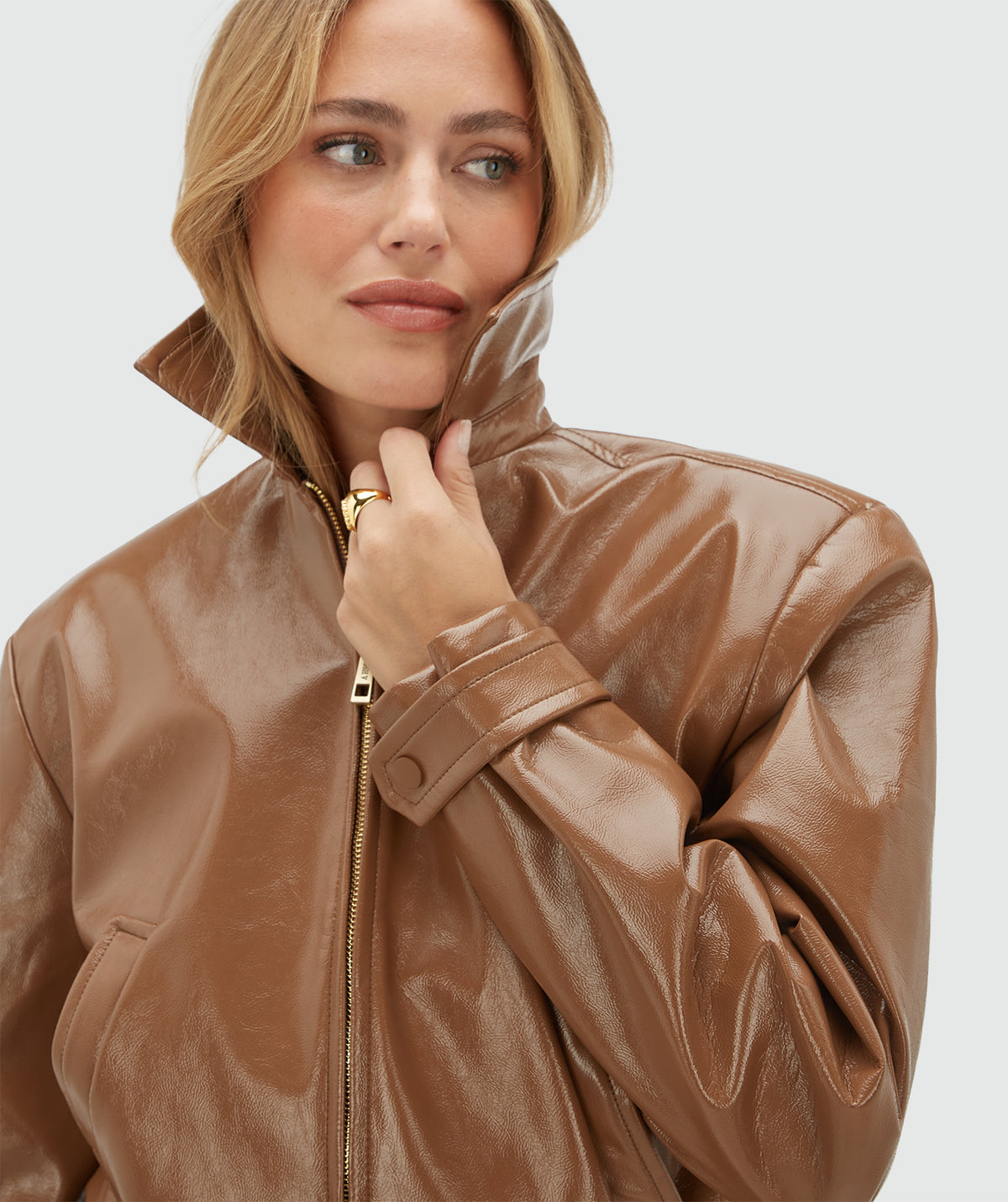 Detailansicht der JOSH V Peaden Damenjacke in Cognac mit glänzender Lederoptik, Kragen und goldfarbenem Reißverschluss