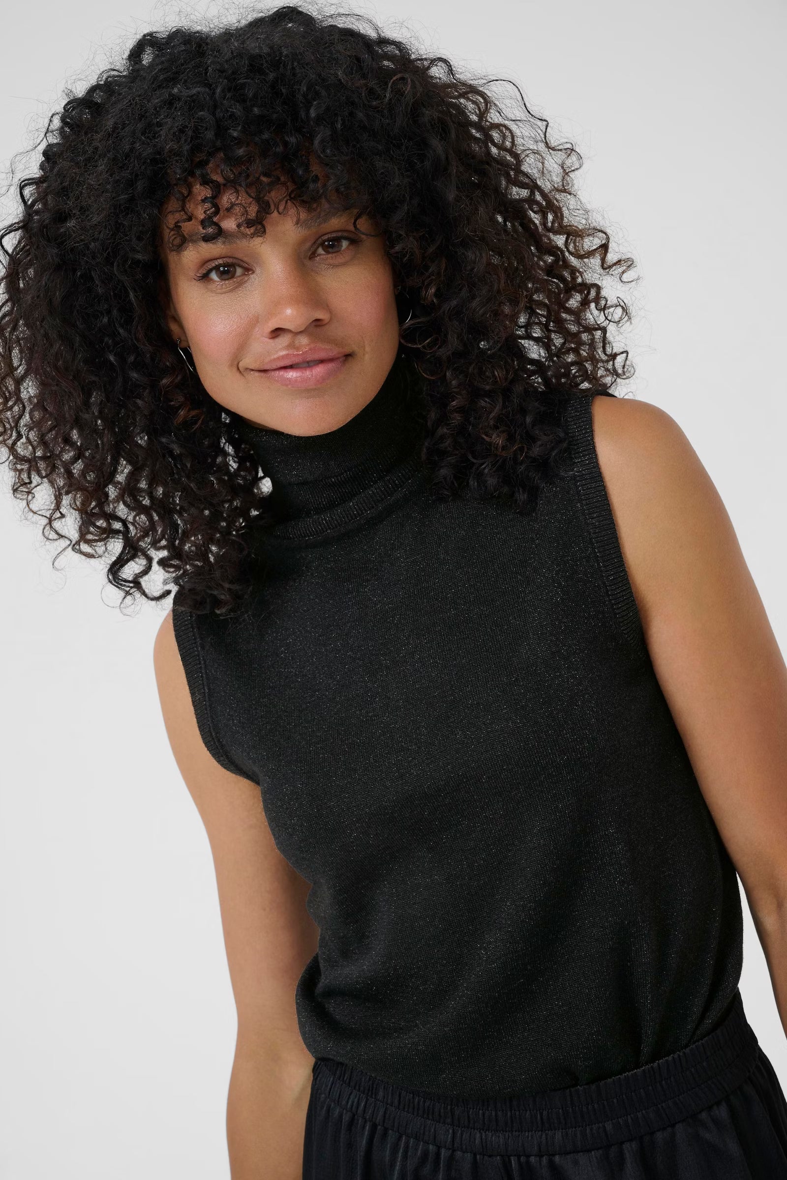 Frau trägt das Kaffee Regina Roll Neck Top Black Deep in Schwarz – Frontansicht, eleganter Rollkragen, schmal geschnitten