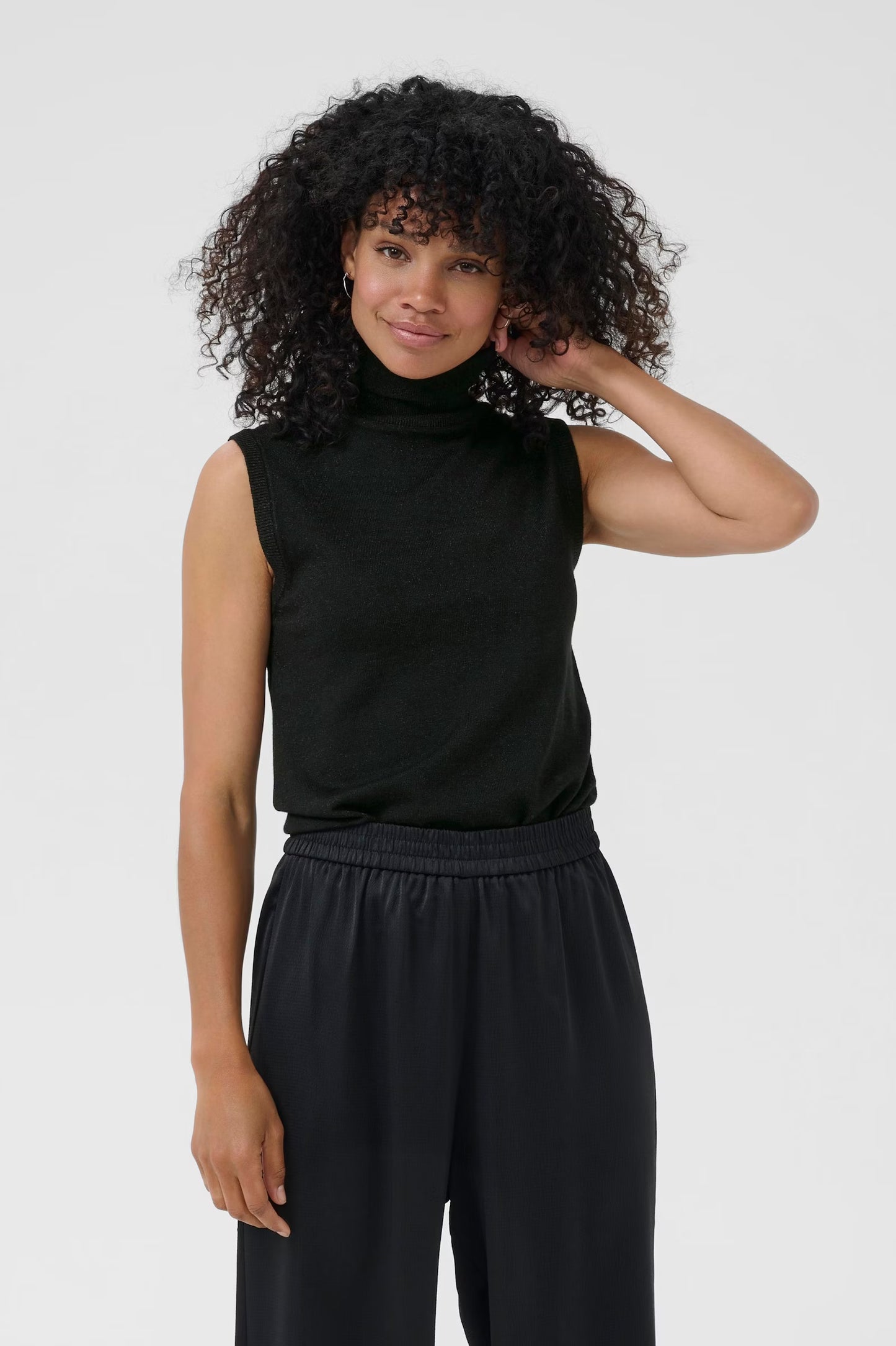 Frau trägt das Kaffee Regina Roll Neck Top Black Deep in Schwarz – Frontansicht, eleganter Rollkragen, schmal geschnitten