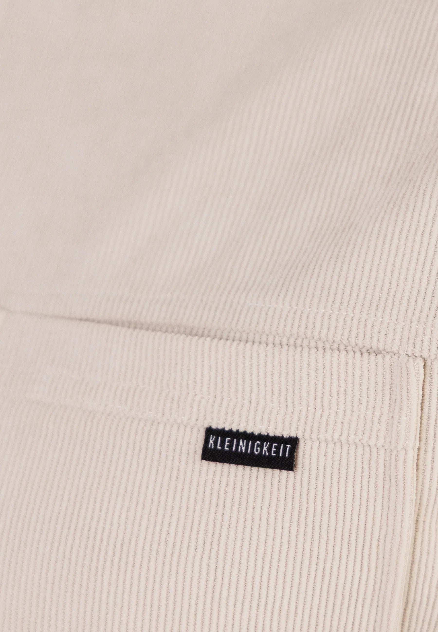 Detailaufnahme des Cordstoffs und Labels beim Kleinigkeit Cordplay Shirt - Frappe mit feiner Struktur.