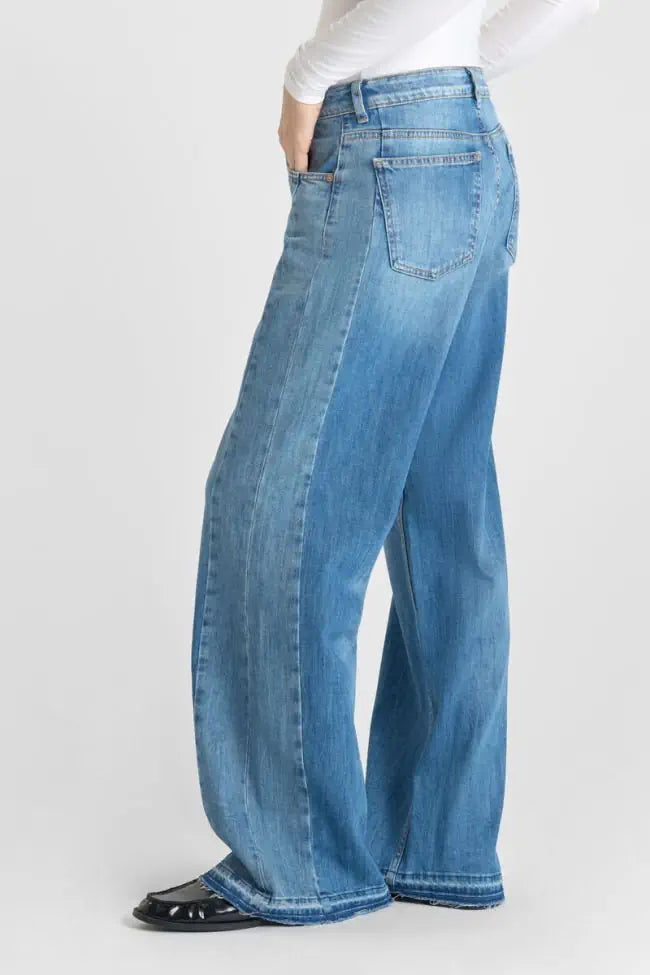 Seitenansicht der Le Temps Des Cerises Lauryn Mid Waist Wide Leg Jeans in Aix Blue N4 mit weitem Bein und fließender Silhouette.