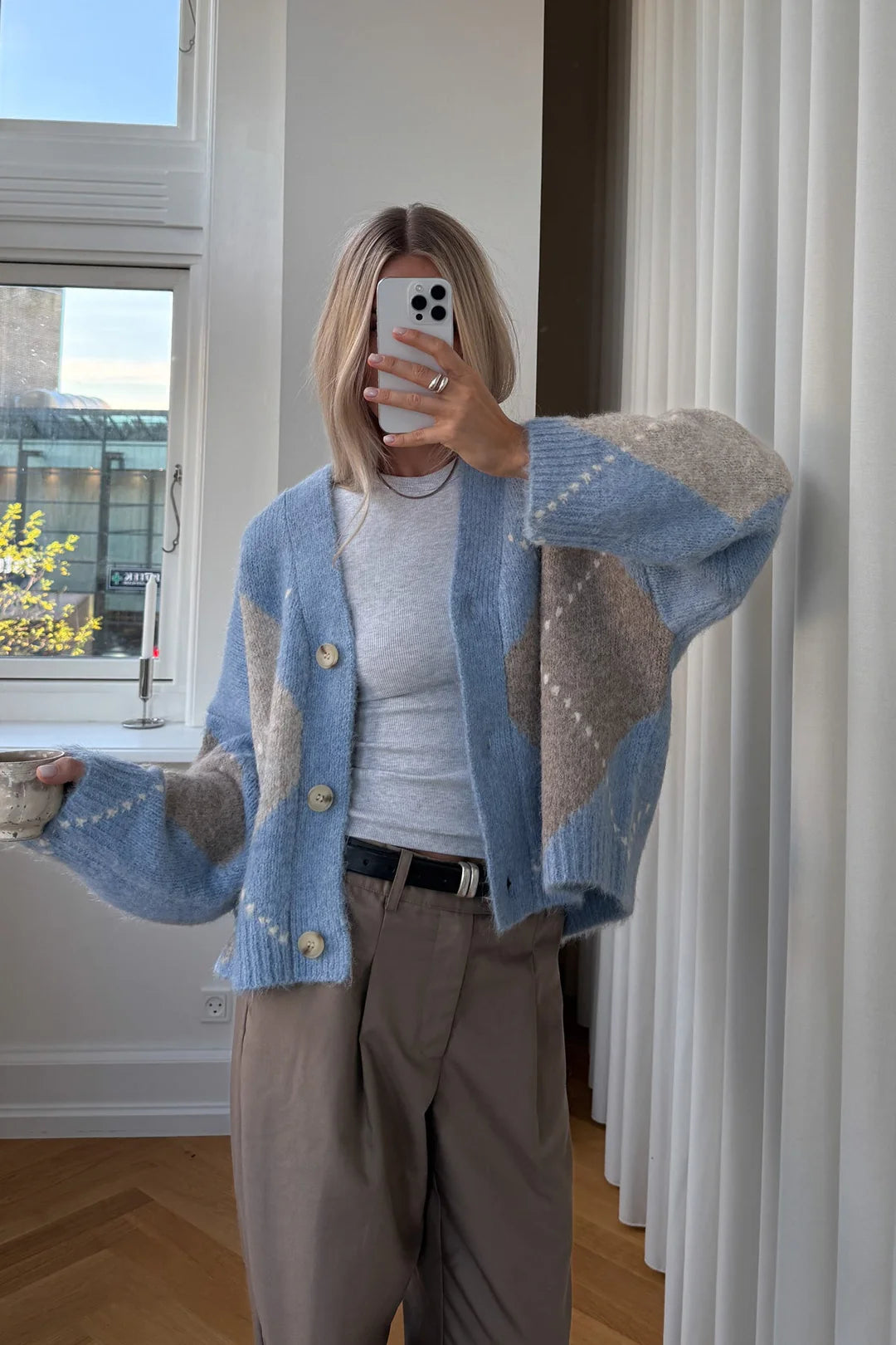 Noella Laiana Knit Cardigan - Sky Blue Mix in einem lässigen Alltagslook, getragen mit T-Shirt und Stoffhose in heller Umgebung.
