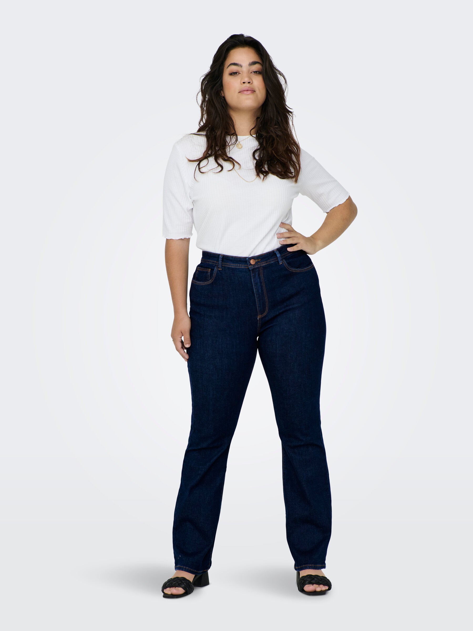 Ganzkörper-Vorderansicht der Only Carmakoma Carsally Flared Jeans in Dunkelblau. Vielseitiges Design mit schmeichelndem Schnitt, ideal für jeden Anlass.