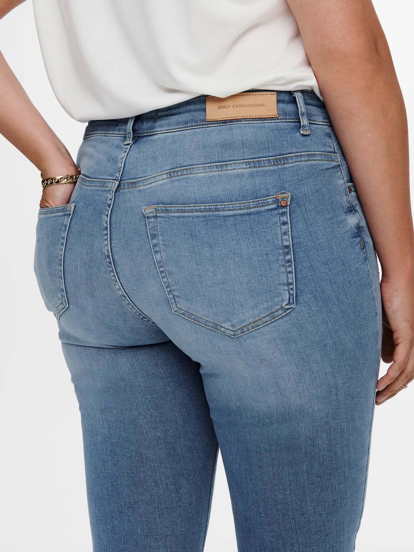 Detailansicht der Gesäßtaschen und des Bundlabels der Only Carmakoma Willy - Regular Waist Skinny Ankle Jeans in Light Blue