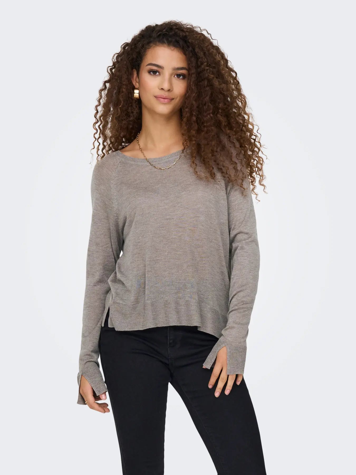 Nahaufnahme einer Frau im Only Vienna Knit Pullover in Satellite Melange, kombiniert mit einer schwarzen Jeans.