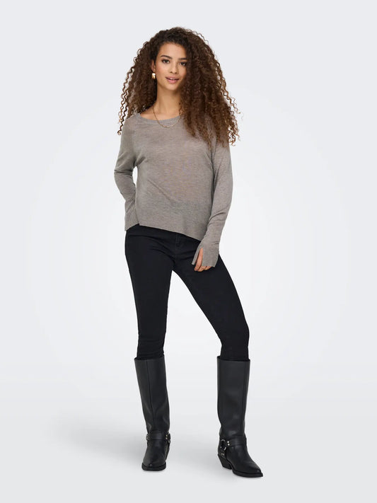 Frau trägt den Only Vienna Knit Pullover in Satellite Melange mit schwarzer Jeans und schwarzen Stiefeln.
