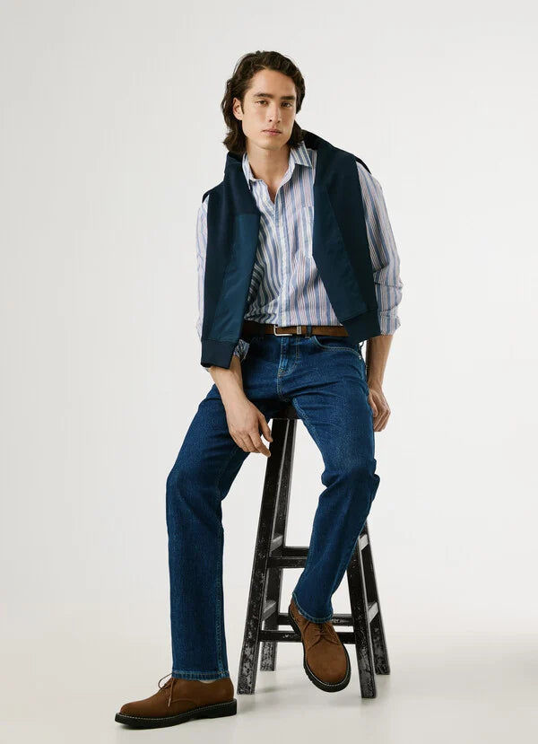 Modell trägt Pepe Jeans London Cash - Straight - 5CB Jeans in kompletter Outfitansicht auf einem Hocker sitzend