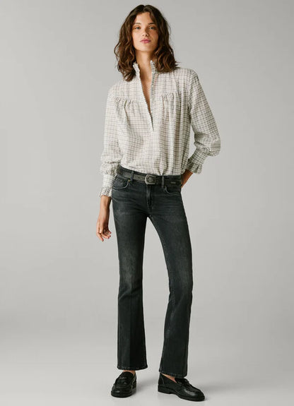 Modell trägt Pepe Jeans London Pimlico Low Waist Flared 9FA in Schwarz – Vorderansicht der ausgestellten Jeans mit Bluse.