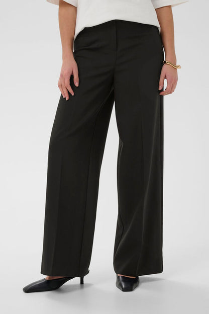 Soaked Corinne Wide Long Pants Black in der Frontansicht – schwarze, weit geschnittene Stoffhose für Business und Alltag.
