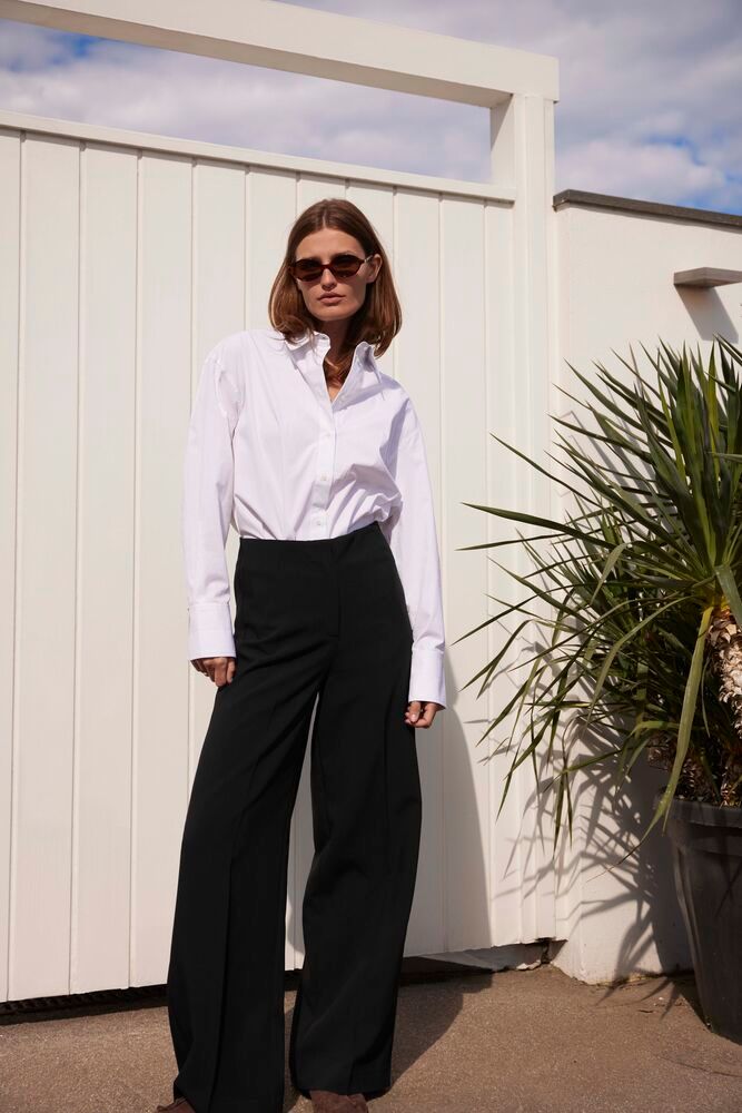 Elegantes Outfit mit Soaked Corinne Wide Long Pants Black, kombiniert mit weißem Hemd – moderner, minimalistischer Look für City und Büro.