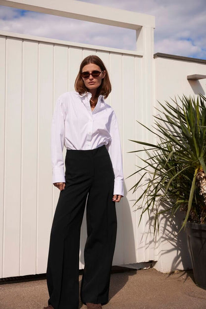 Elegantes Outfit mit Soaked Corinne Wide Long Pants Black, kombiniert mit weißem Hemd – moderner, minimalistischer Look für City und Büro.