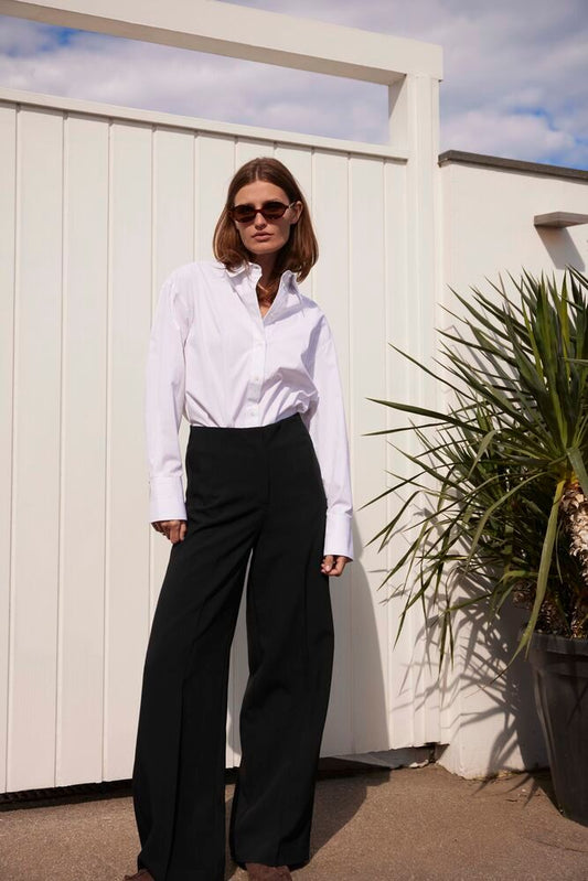 Elegantes Outfit mit Soaked Corinne Wide Long Pants Black, kombiniert mit weißem Hemd – moderner, minimalistischer Look für City und Büro.
