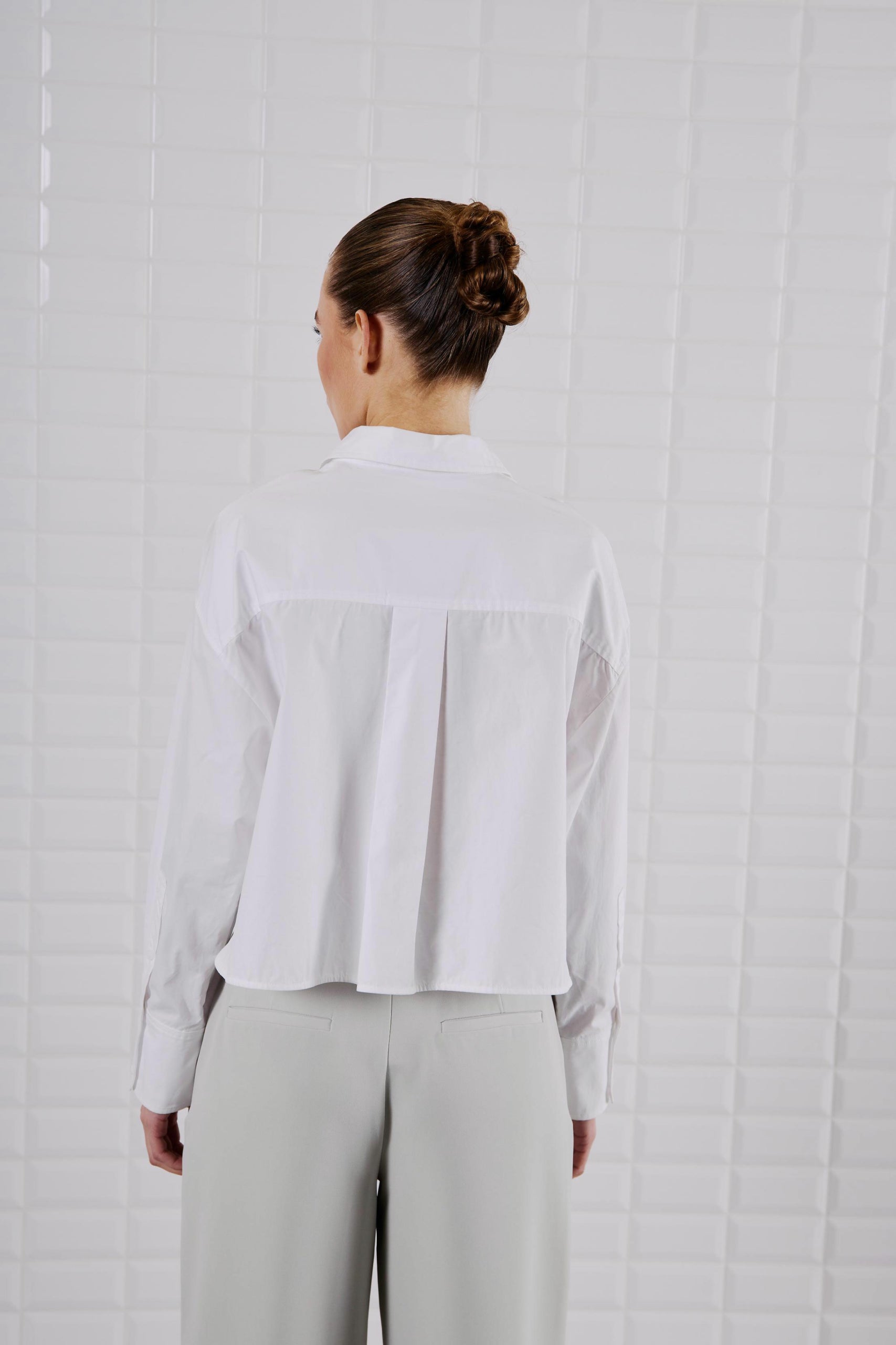 Rückansicht des WithBlack Shorty Soft Cropped Shirt in Weiß, locker fallend mit taillierter Länge.
